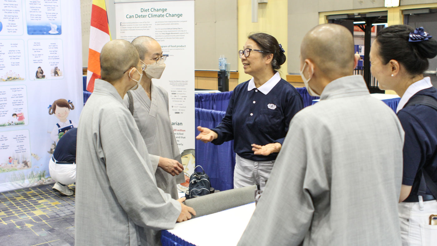 La directora general de Tzu Chi USA, Debra Boudreaux, presenta las exhibiciones a las Maestras del Dharma en el evento. Foto/Jennifer Chien