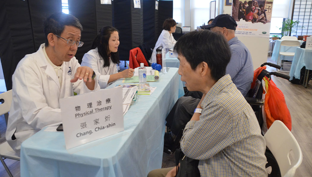 Physical therapist Joe Chang (left) and Haili Gao (second left) both consult patients