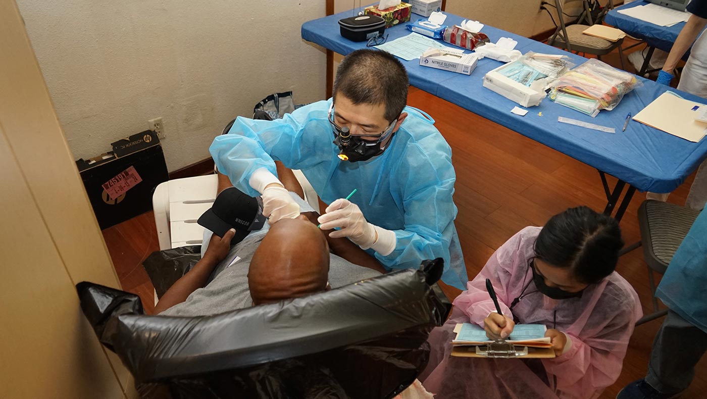 張凱喬教授（中）在慈濟鳳凰城的第一次牙科義診中為病患看牙。攝影／錢美臻