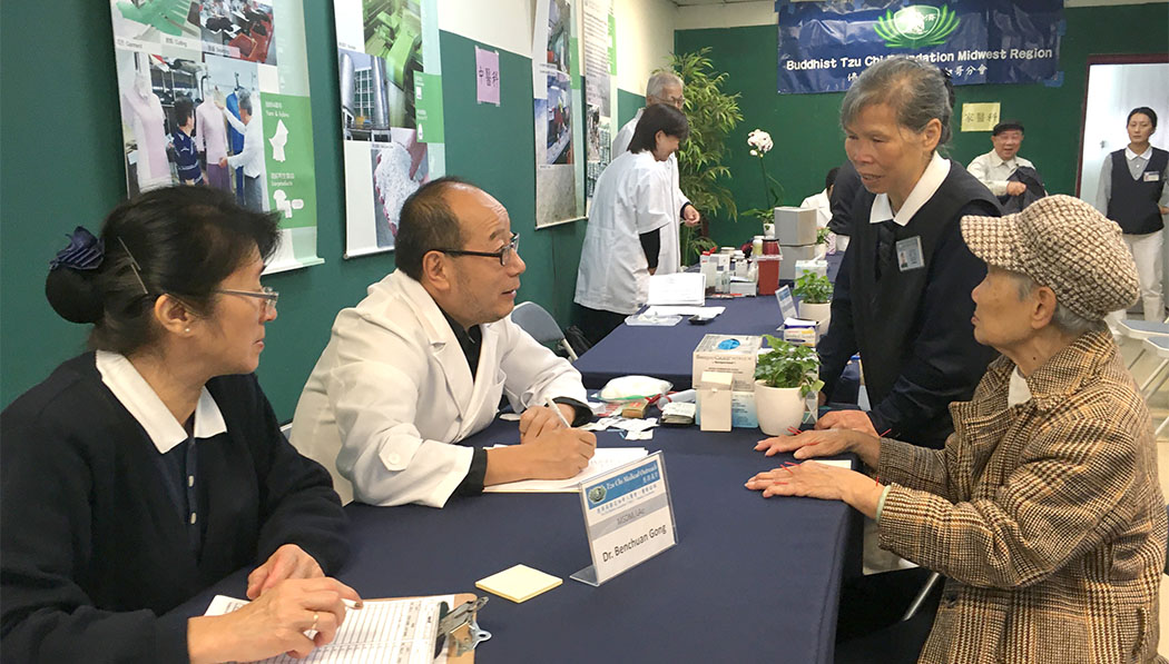 Traditional Chinese Medicine doctor Benchuan Gong (second left) consults patients