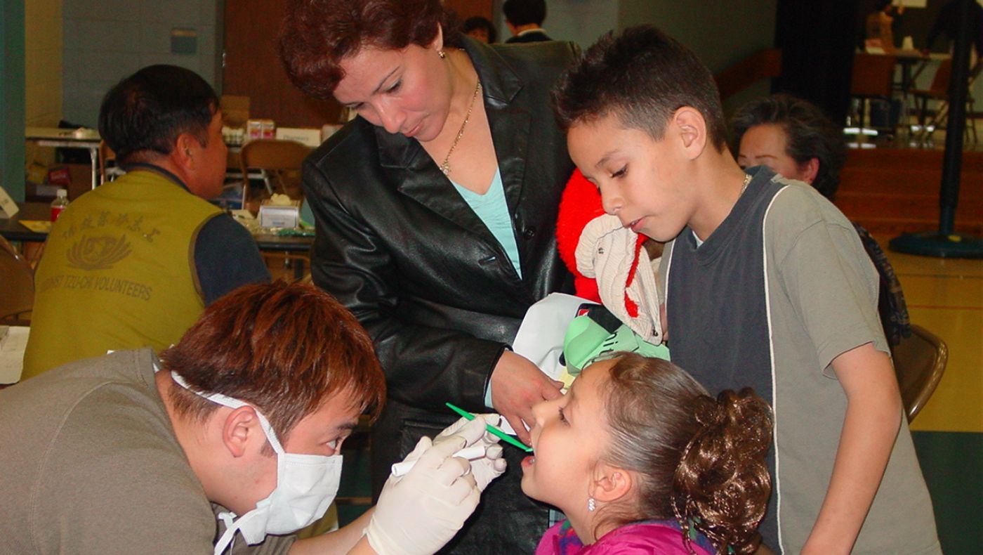TIMA dentist conducting oral check up to a kid