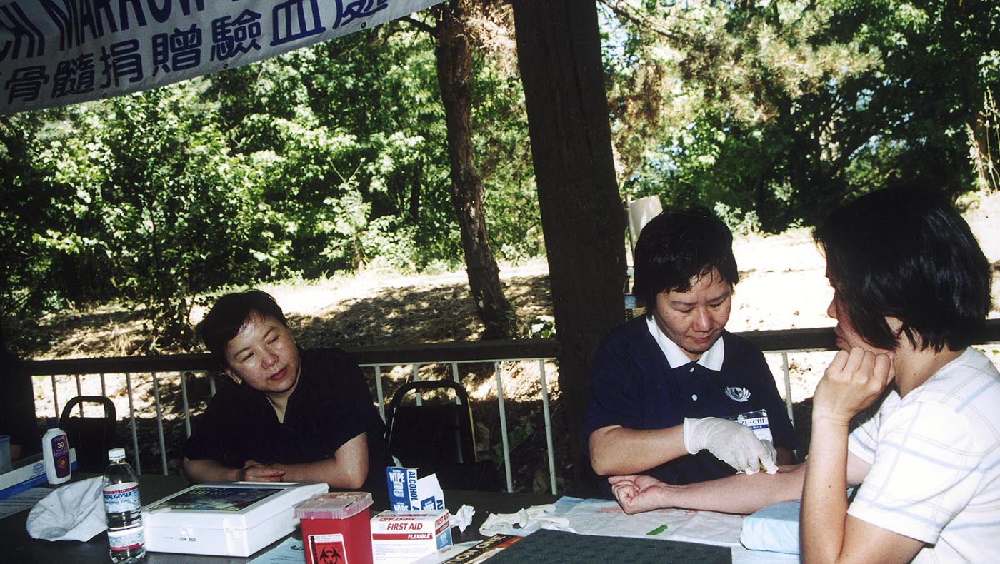 During a bone marrow donation event on July 7, 2001, medical volunteer Anqi Zhan (middle) helps draw blood samples. Photo/Tzu Chi USA Northwest Region