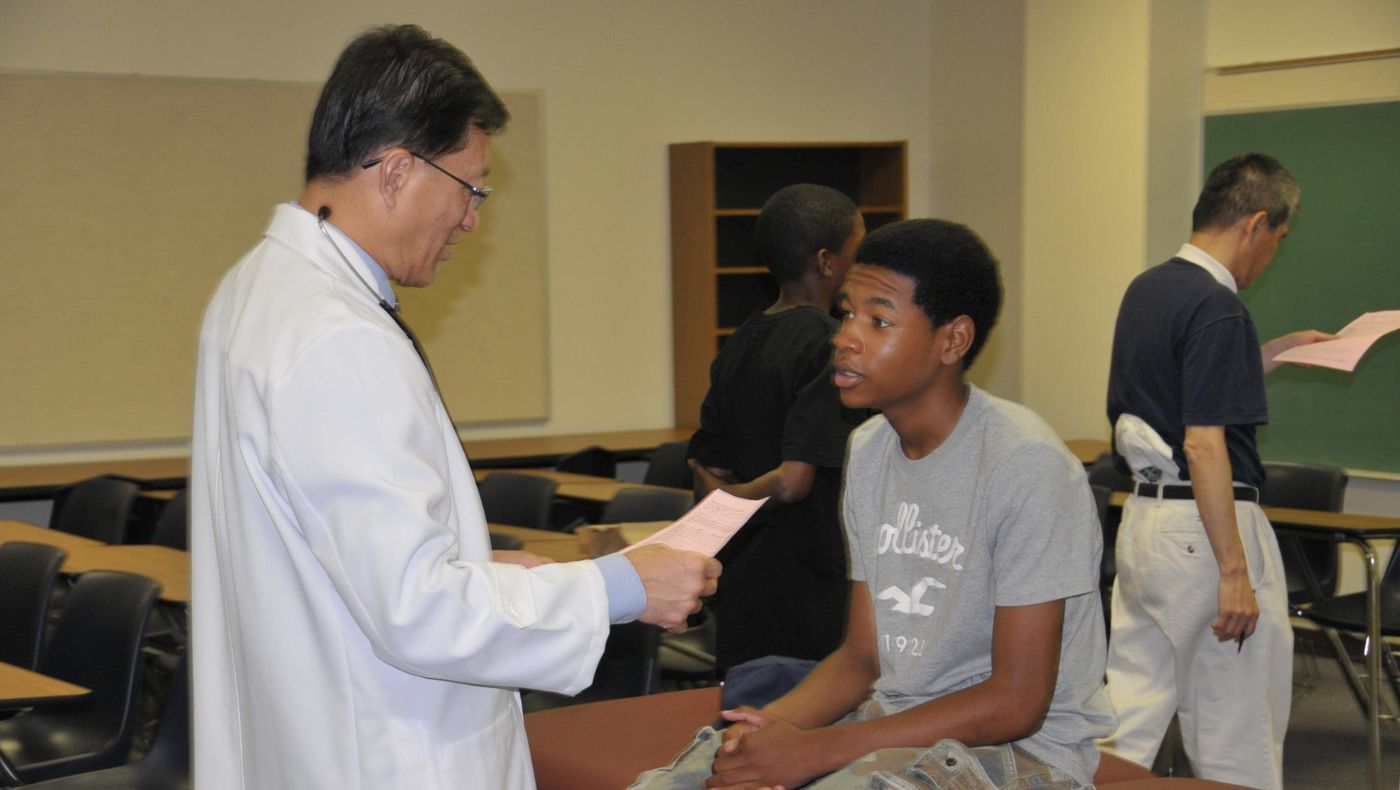 Dr. Lieu, the vice-convener of the TIMA USA Central Region chapter, conducts health examinations for students from underrepresented communities