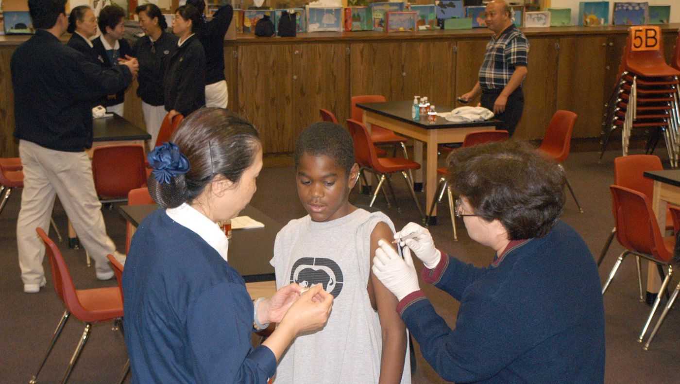 Tzu Chi USA’s Central Region TIMA volunteers giving flu vaccine to a student