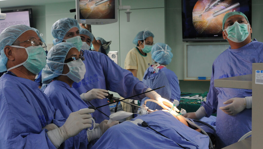 Dr. Peter Chan (first from left) carefully demonstrates gastrointestinal minimally invasive surgery for Dr. Boguo.