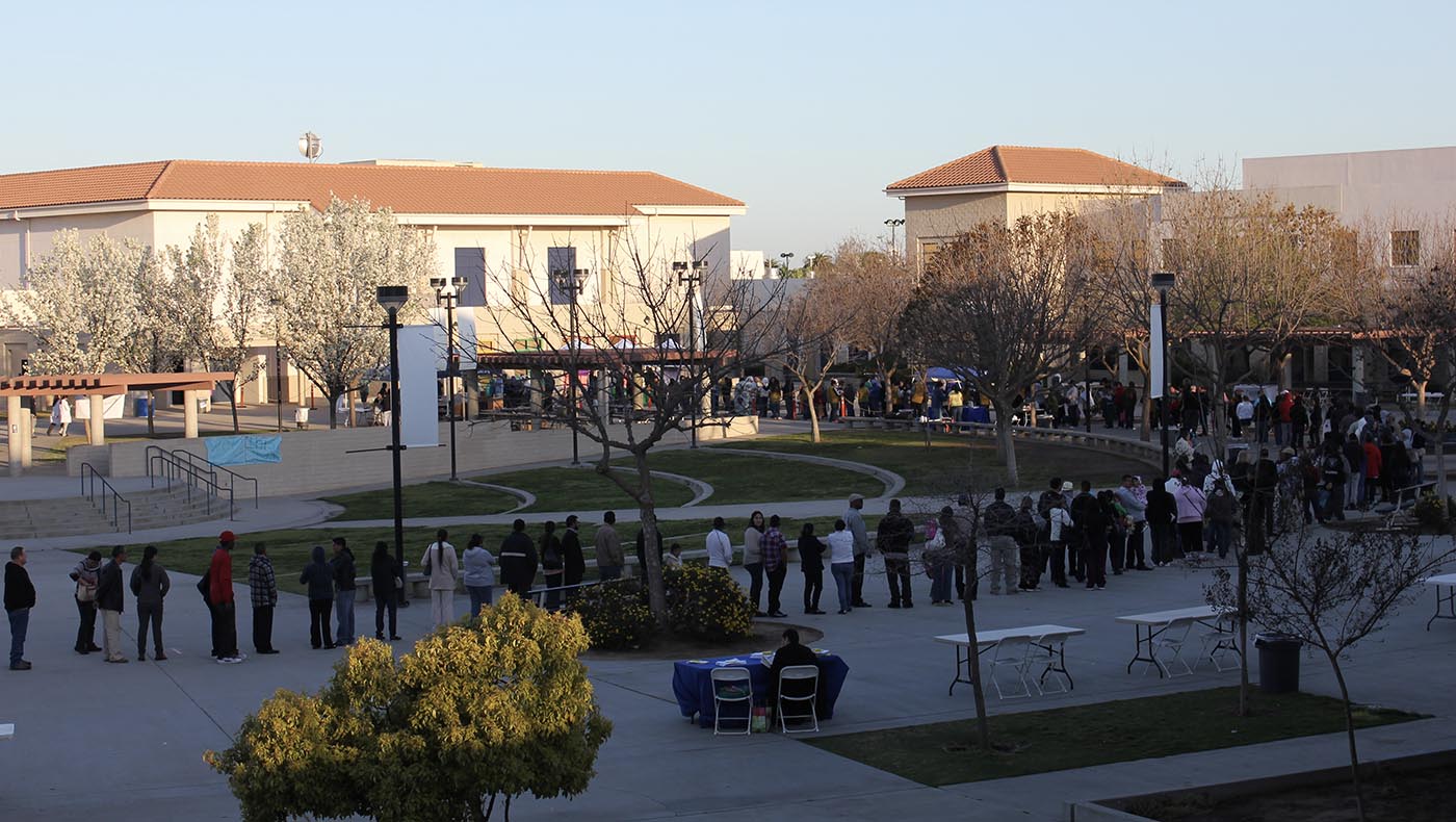 People queue up in a long line and wait to see a doctor at a free clinic event in Fresno on March 15, 2013