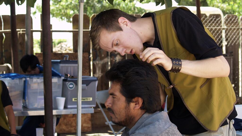College student Kevin Nelson volunteers as a barber during Tzu Chi’s mobile healthcare outreach