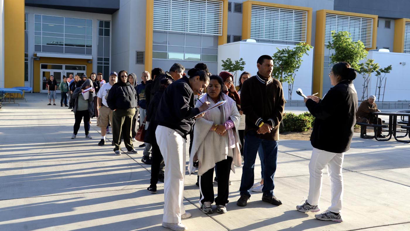 People wait in line to enter the venue for a free clinic event in Fresno.