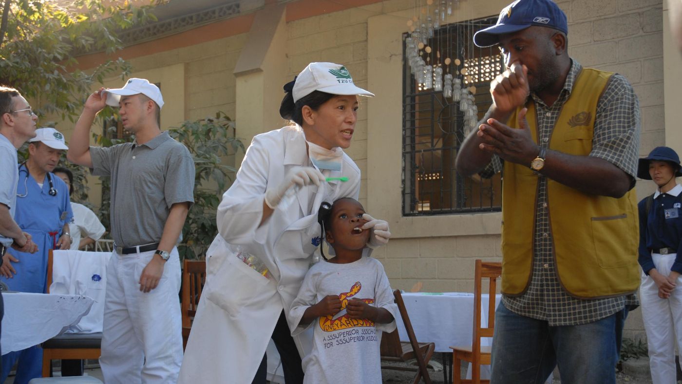 When Haiti was hit by a magnitude 7.0 earthquake on January 12, 2010, the Tzu Chi Medical Team conducted free clinics in Paroisse Croix Des Missio. Shirley Chen provides dental hygiene education to the public through an interpreter.