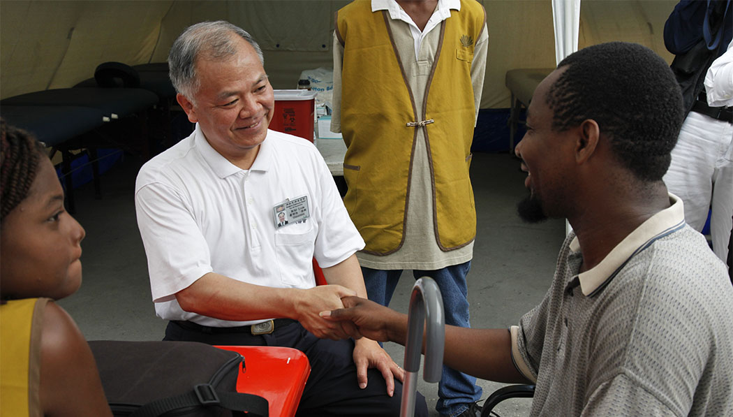 Clarelsom (right) shaking hand with Chinese medicine practitioner