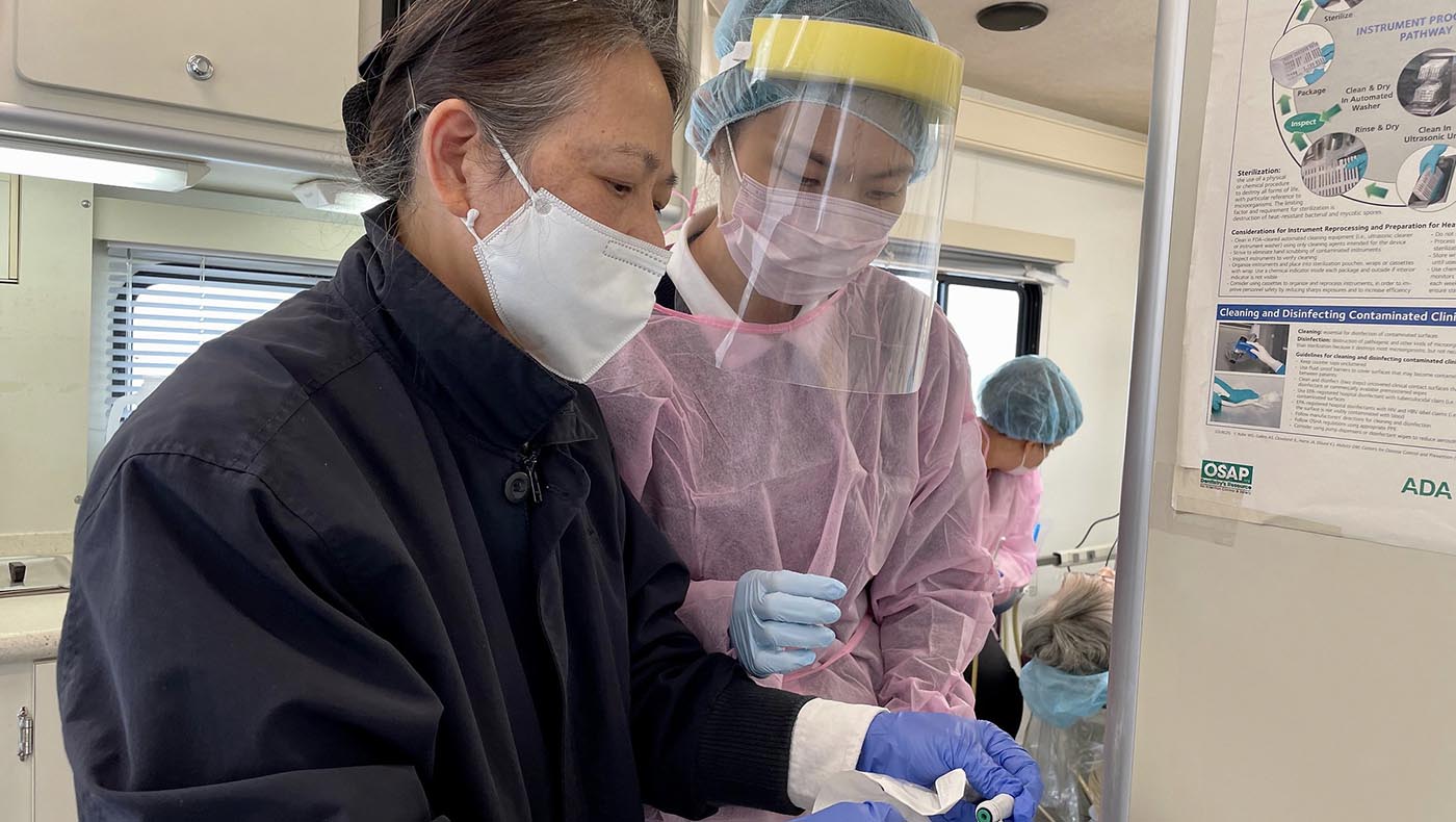 2023年十一月，在聖荷西定點義診中，林美秋（左）指導牙科助理，準備補牙的材料。攝影 ／劉翰卿