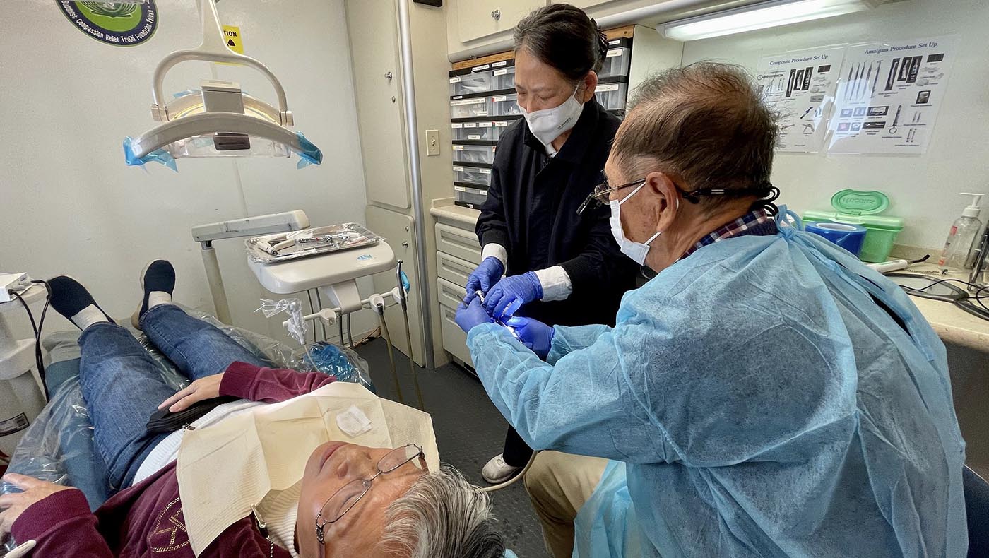 2023年十一月的聖荷西定點義診，在醫療車上，林美秋（中）協助牙醫師朴樞更換洗牙器的噴頭。攝影 ／劉翰卿