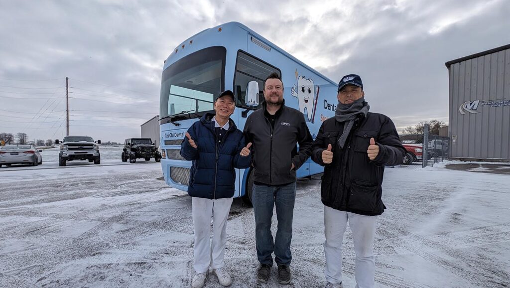 Tzu Chi USA Northeast Region volunteers Jinghua Chen (left) and Yanping Gong (right) take a photo with Corie Rayman (middle), Deputy Director of Operations at the factory that manufactured the new Tzu Chi Dental Mobile Clinic vehicle. The two volunteers spent a day traveling 710 miles to Indiana to pick it up, then drove another day to get back to New York. Photo/Courtesy of Tzu Chi USA Northeast Region