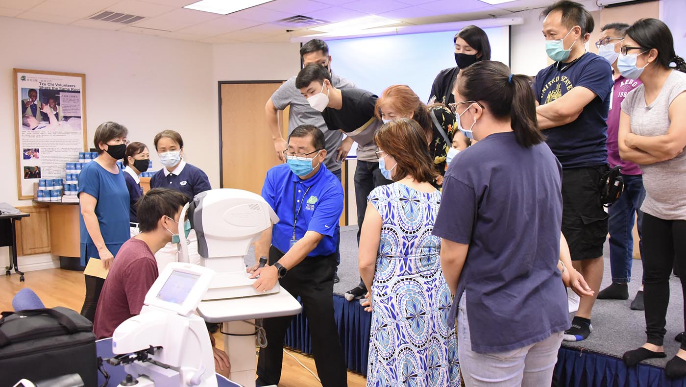 Steven Voon explains how to operate optometry equipment during a training session.