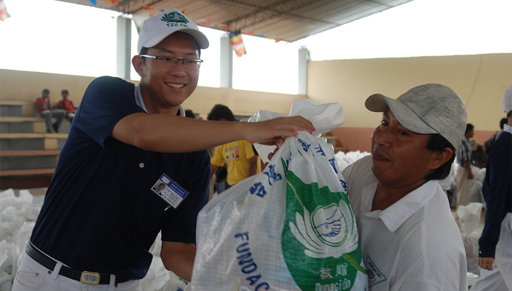 Jack Fan handing distribution items to local people