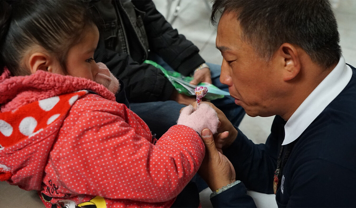 Tzu Chi volunteers comfort the little girl with candies