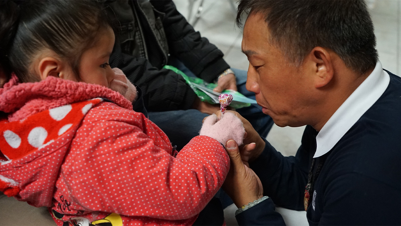 Tzu Chi volunteers comfort the little girl with candies