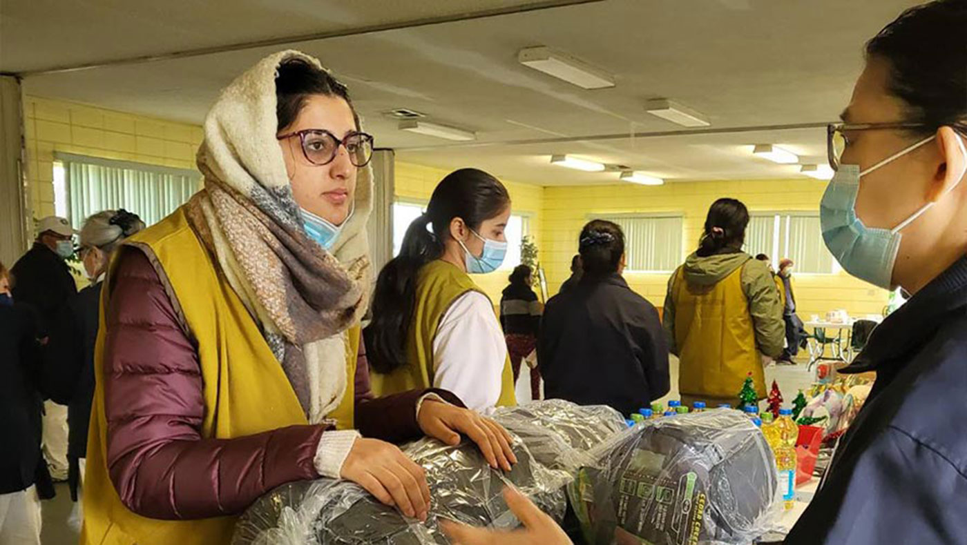 Tzu Chi Fresno volunteers invite Sara (left), an Afghan refugee and care recipient, to participate in a distribution in 2022. Photo/Yuanling Cho
