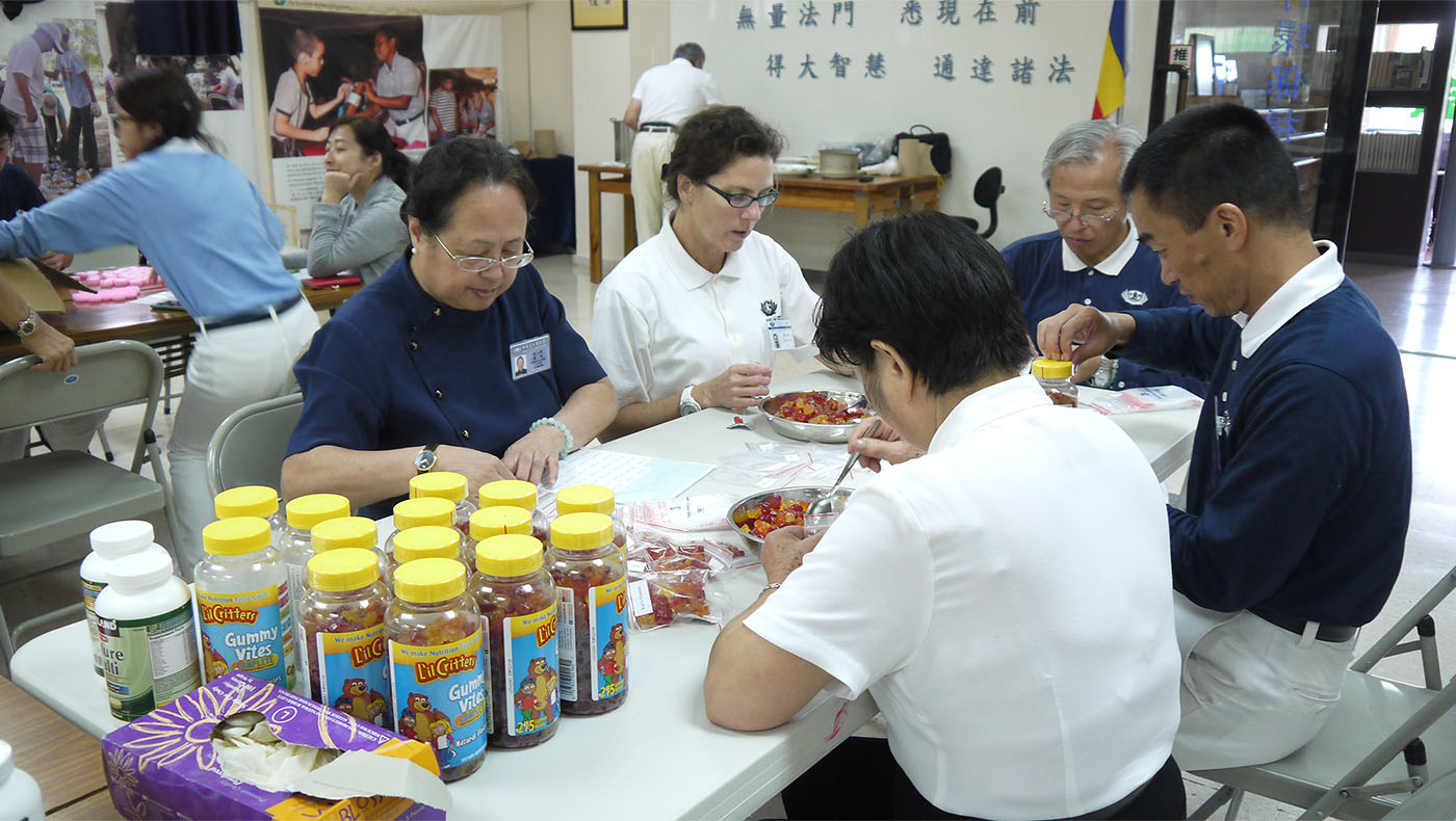 Debby and other volunteers packing gummy vitamins for children and medicines