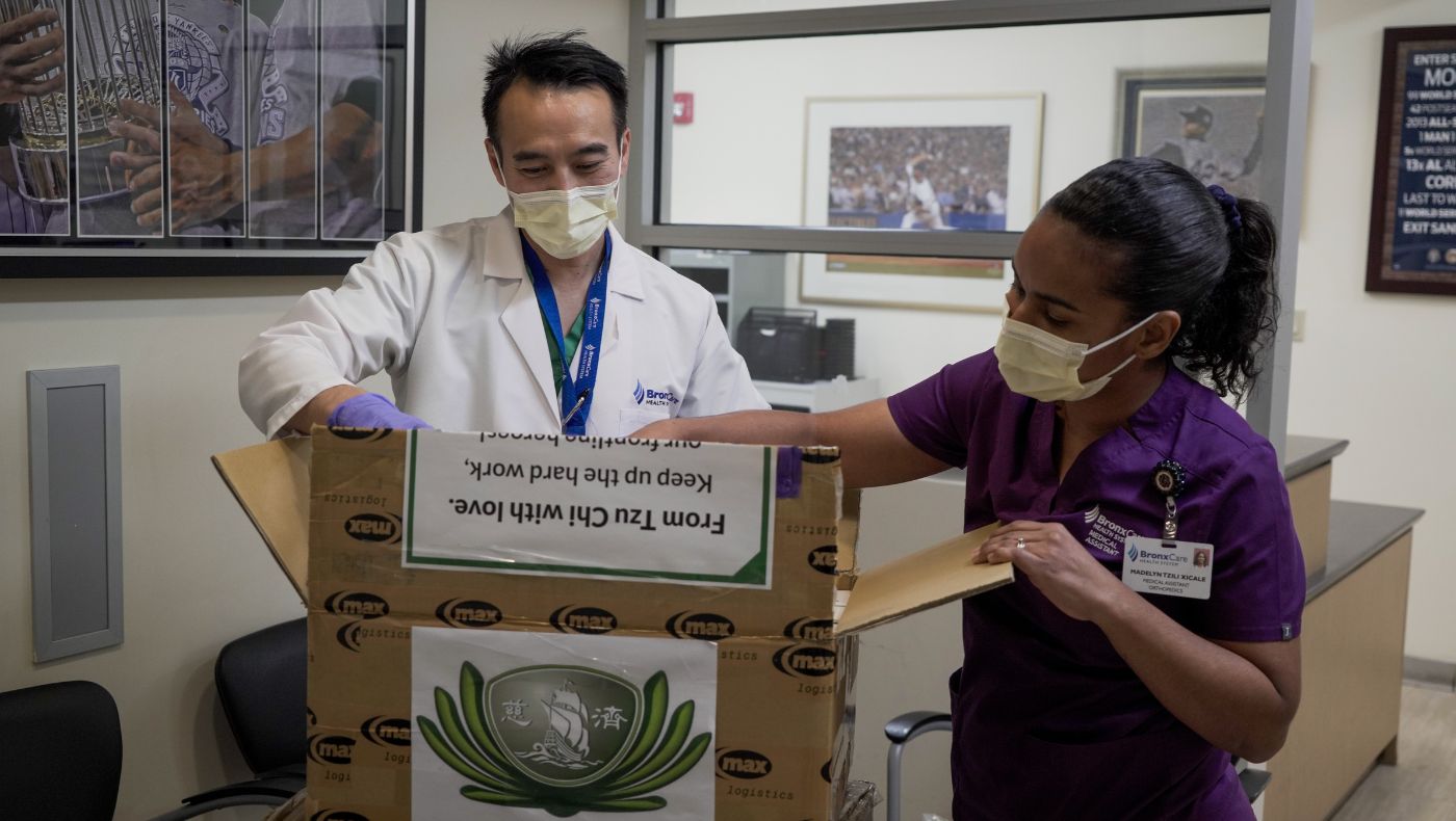 Dr. David Wang unpacks the anti-epidemic materials donated by the New York branch.