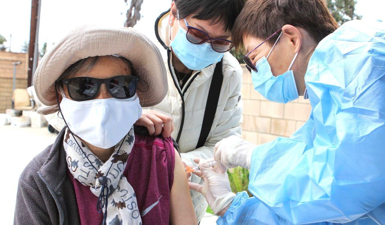 An elderly person in the community receives the first dose of the COVID-19 vaccine.