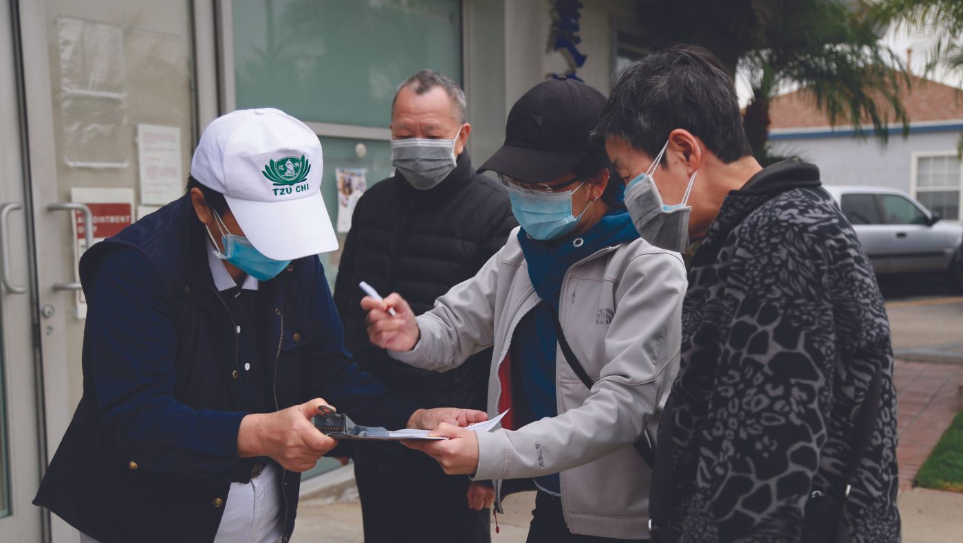 Tzu Chi volunteers help people who come to receive vaccinations to fill in the necessary forms.