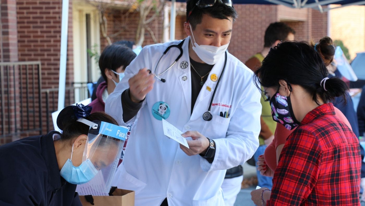 Dr. Ruan Liansen (middle) from Victoria cooperates with Tzu Chi to distribute food to low-income families affected by the epidemic in front of his clinic in Qijiao District, Fairfax County, to maintain nutritional intake and enhance immunity.