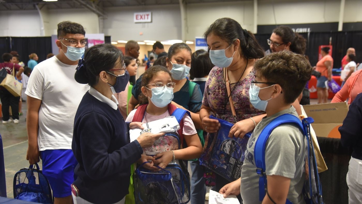 Tzu Chi volunteers cordially informed families of school children at the Dallas Mayor’s Homecoming Day that in addition to school uniforms, they would also receive other items including epidemic prevention supplies.