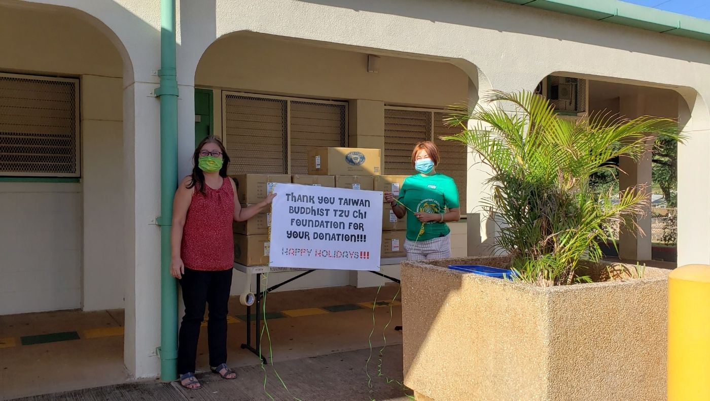 A representative from the Hawaii Department of Education took a photo holding a hand-drawn poster that read "Thank you Taiwan Tzu Chi Buddhist Foundation for your donation and wish you a happy holiday!" to thank the volunteers for their generosity on the occasion of Christmas 2020 Donated supplies.