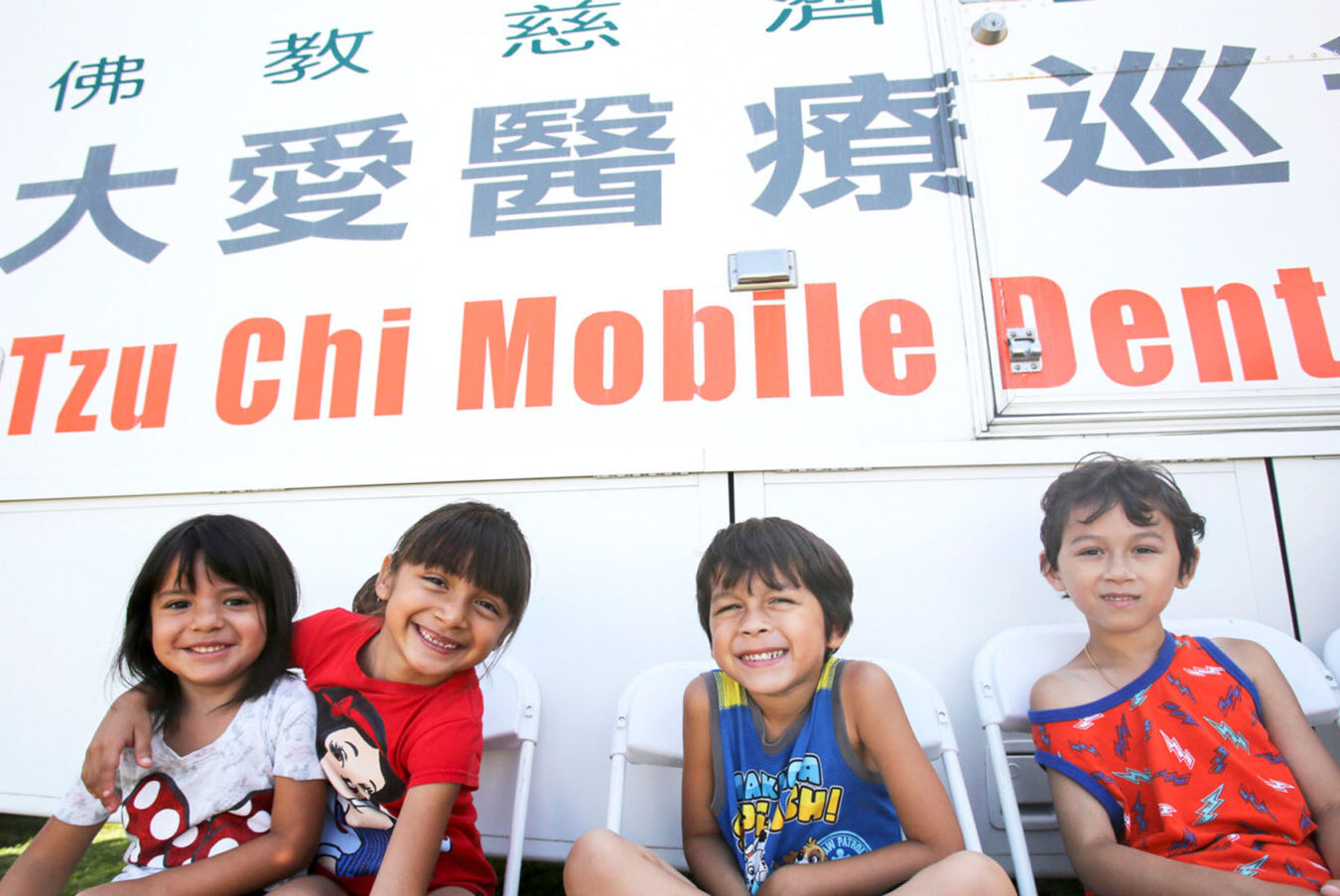 children wait to be seen outside Tzu Chi USA’s Dental Mobile Clinic