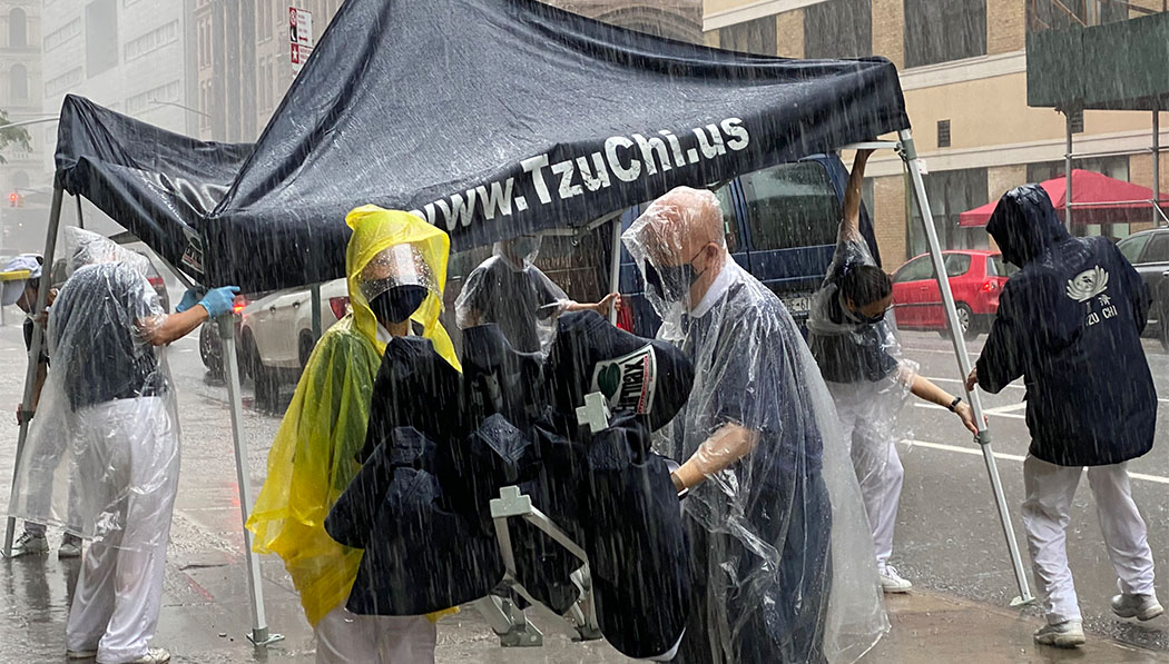 Despite the pouring rain, Tzu Chi New York’s Manhattan Service Center volunteers set up tents for a grocery distribution on July 10, 2020.