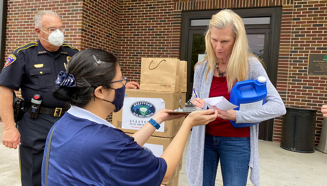 After being severely hit by Hurricane Harvey in 2017, Southern Region volunteers continue to provide care for Dickinson, Texas. In April 2020, Mayor Julie Masters receives medical masks and disinfectant for use by the municipality and police department.