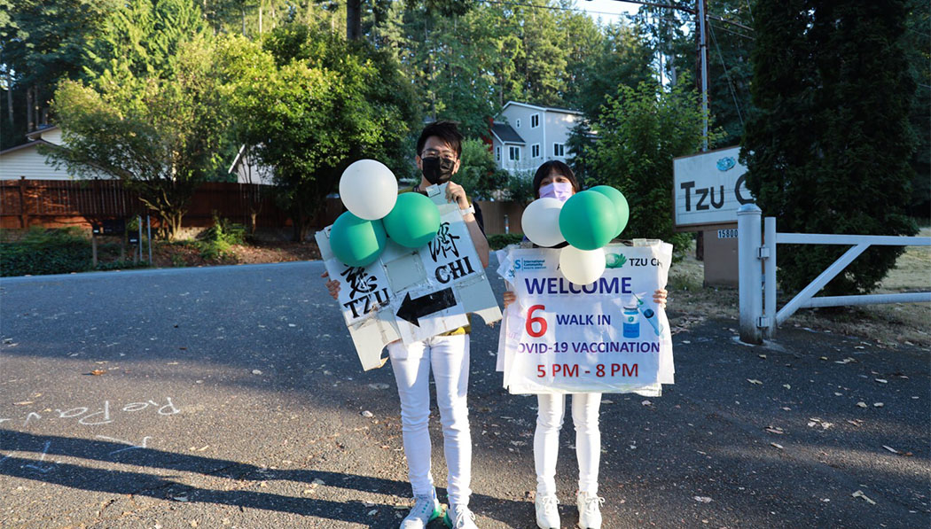 Young Tzu Chi volunteers hold signs for a vaccination event at the Seattle Branch office in July 2021