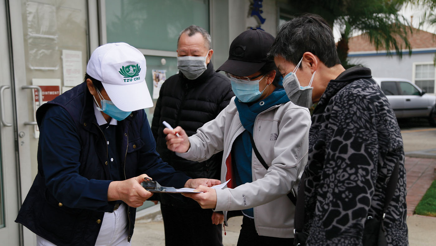 Families begin filling out pre-vaccine paperwork with the help of Tzu Chi volunteers.