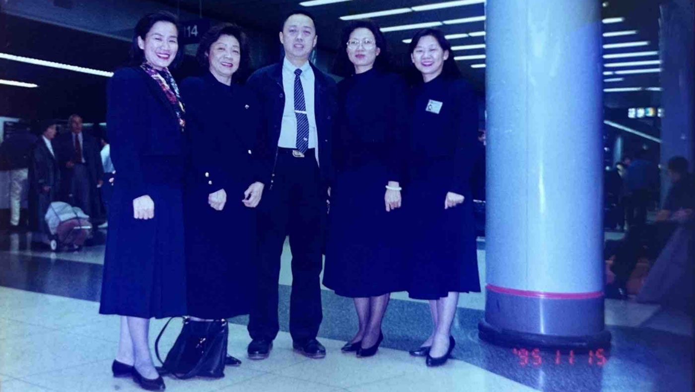 Stephen Huang (centro), Lusha Chen (izquierda), Pinien Hou (segunda desde la izquierda), Lingchai Tung (segunda desde la derecha) y Shuchen Wang (derecha) se toman una foto grupal en un aeropuerto el 15 de noviembre de 1995. En los primeros años, los voluntarios de Tzu Chi viajaban por todo el país para organizar fiestas de té, difundir la filosofía de Tzu Chi y ayudar a voluntarios de otros lugares de los EE. UU. a establecer nuevas sucursales. Foto/Cortesía de Lusha Chen