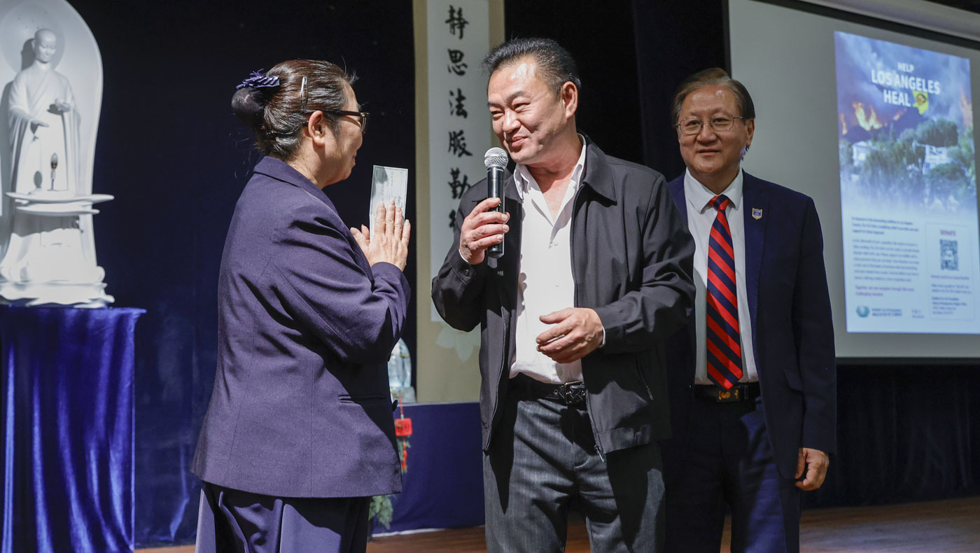 Jason Su, Honor President of the Hainan Association of Southern California, and the association’s President, Sean Hang, make a donation to Tzu Chi USA at the interfaith prayer service. Photo/Shuli Lo