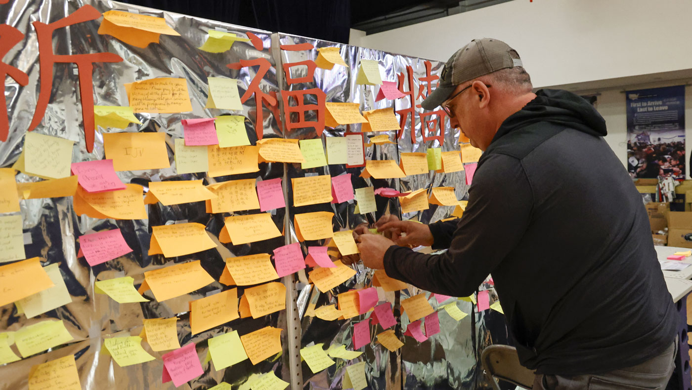 A care recipient adds to the “Prayer Wall” that Tzu Chi volunteers set up at the San Gabriel Valley Service Center. Photo/Shuli Lo
