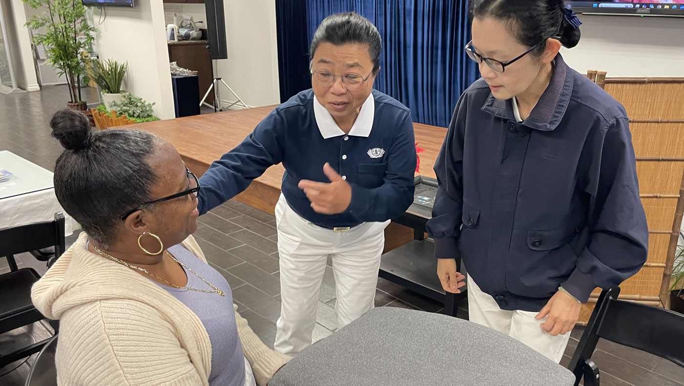 Felisa Wright enjoys connecting with Tzu Chi volunteers while receiving an eco-blanket. Photo/Jennifer Chien