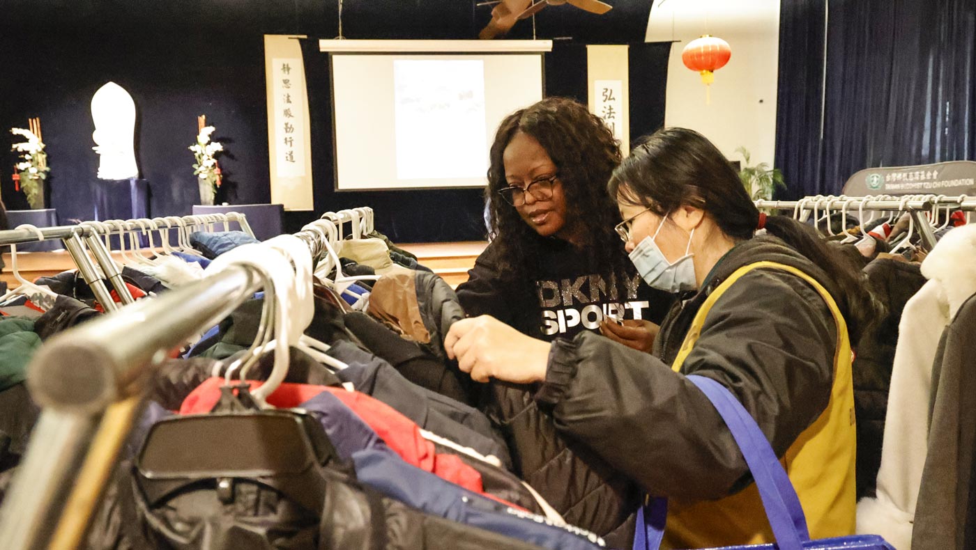Johnetta Turner, asistida por una voluntaria comunitaria de Tzu Chi, elige ropa entre las donaciones. Foto/Shuli Lo
