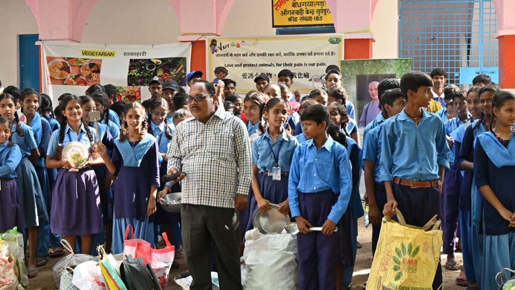 With their cooking utensils from home in hand, Suryapura Middle School students wait as Principal Bajnath Kumar (front) prepares to start the vegetarian cooking competition. Photo/Chunchih Cheng