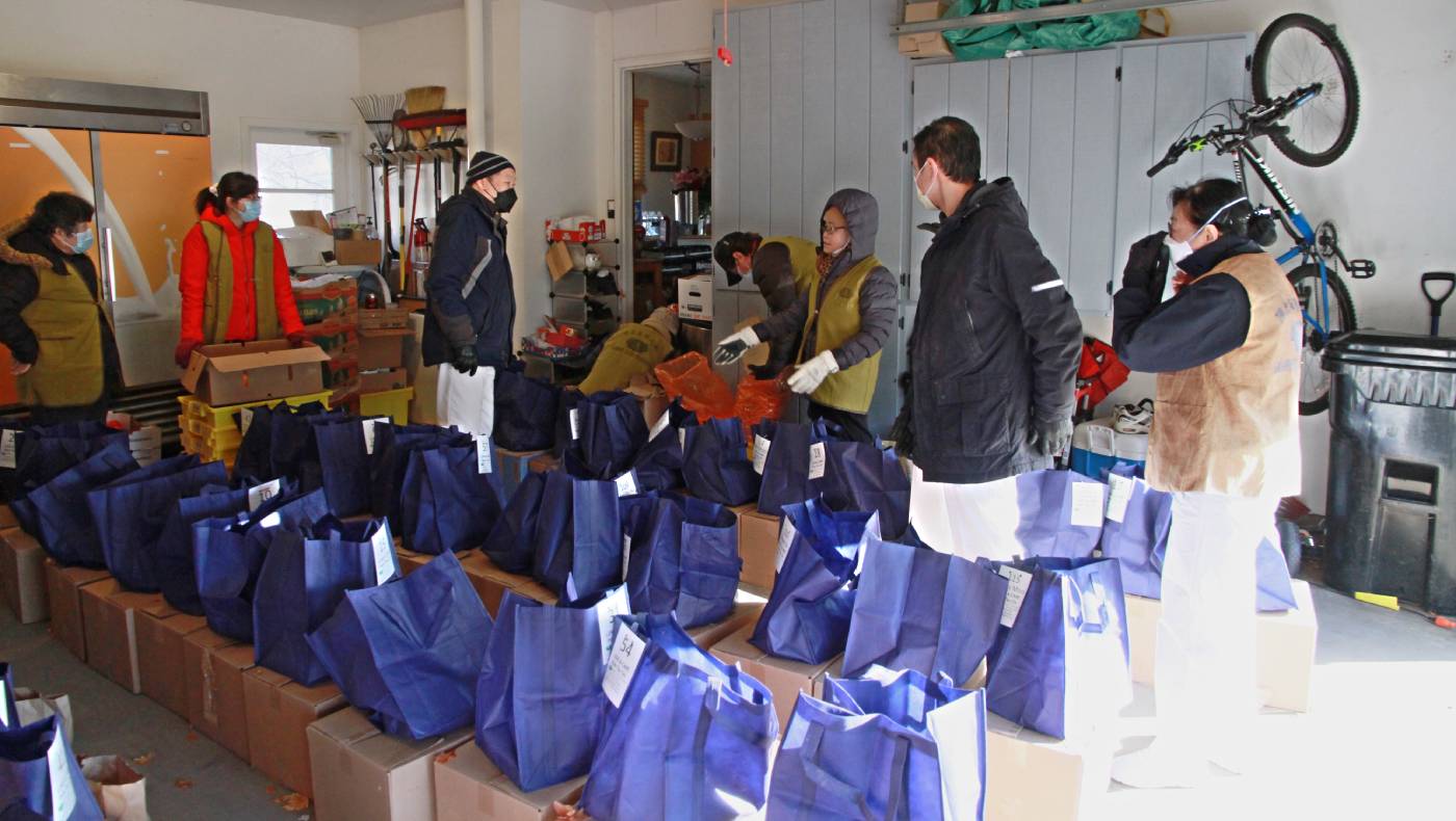 March in Minnesota is still freezing cold. Before local grocery stores offered their indoor space for the volunteers to use, they had to bundle up to pack fruits and vegetables for distribution in Tzuying Pan’s garage. Photo/Tzuying Pan