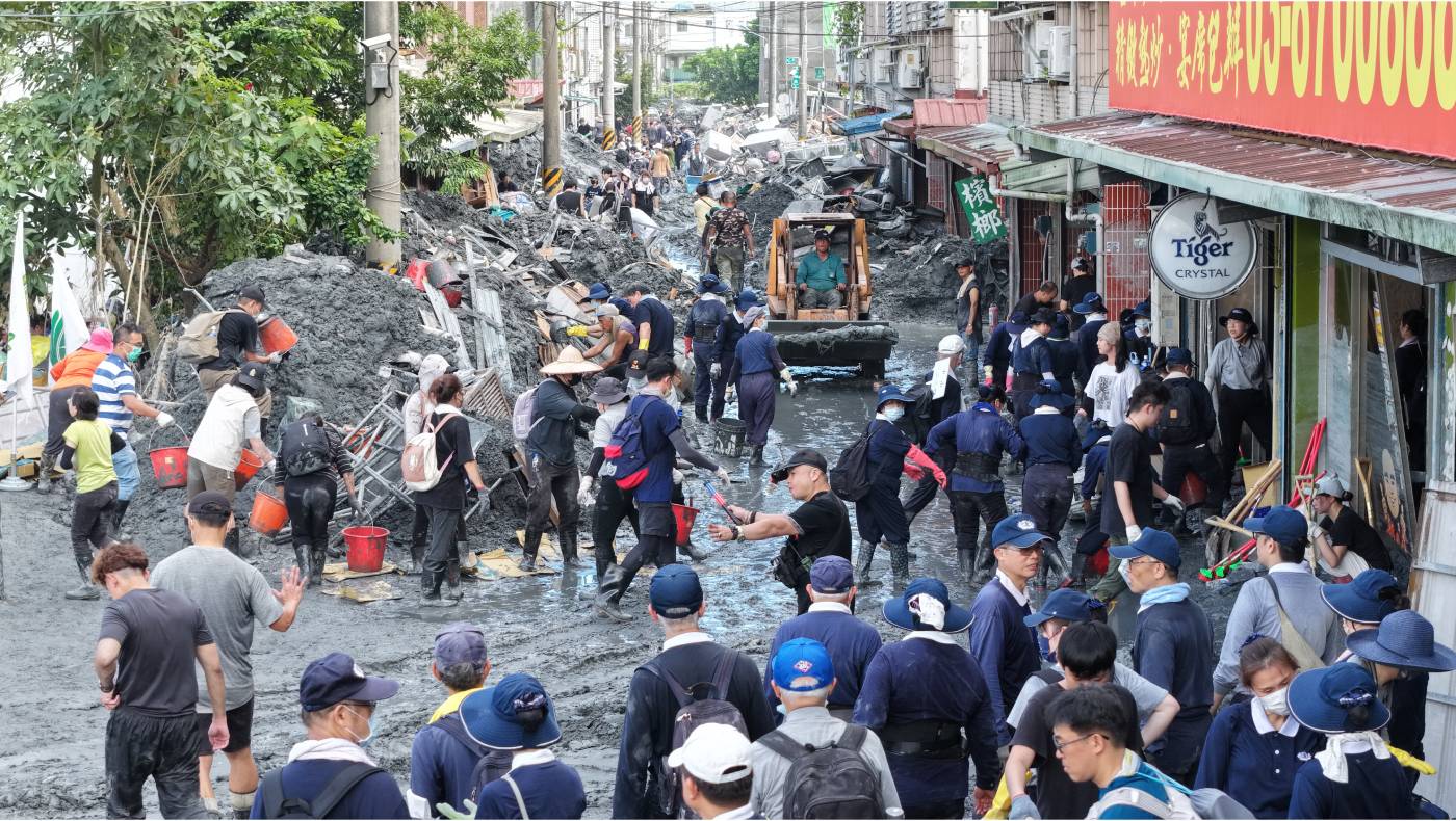 The muddy sludge contains unknown pollutants, including feces, pesticides, batteries, gasoline, and garbage. Yet, Tzu Chi volunteers and the Shovel Superheroes fearlessly wade into the disaster area, undeterred. Photo/Shaomin Chen Li