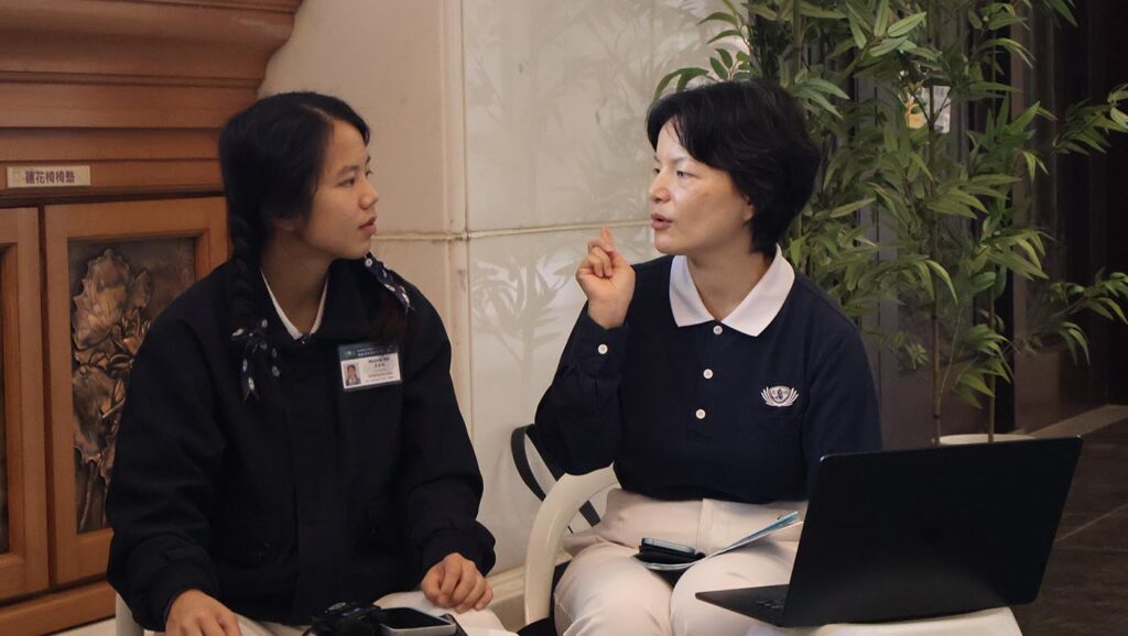 Melinda Wu discusses course content with a staff member.