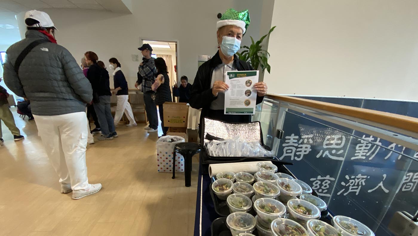 志工在2025年12月20日的食物發放中，與民眾分享示範餐食。攝影／許春蘭