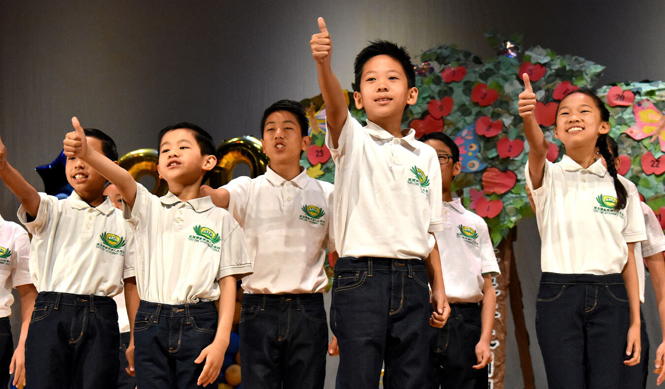 a group of students giving thumbs-up to an audience at a Tzu Chi Academy