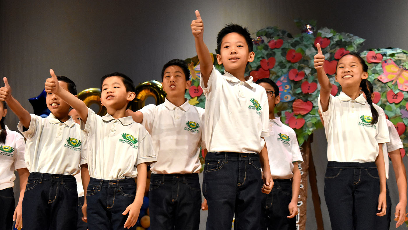 a group of students giving thumbs-up to an audience at a Tzu Chi Academy