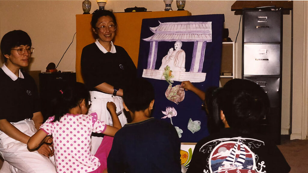 Three children and two adults interact with a purple board featuring a drawing of a person.