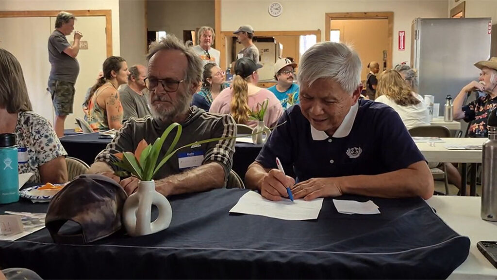 Tzu Chi USA Northwest Region Deputy Executive Director Minjhing Hsieh (right) joins a table discussion during the volunteer orientation event.
