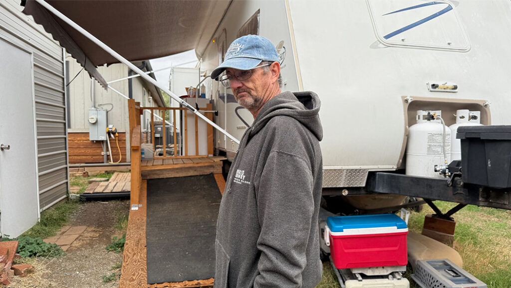 James Morris stands outside the RV trailer