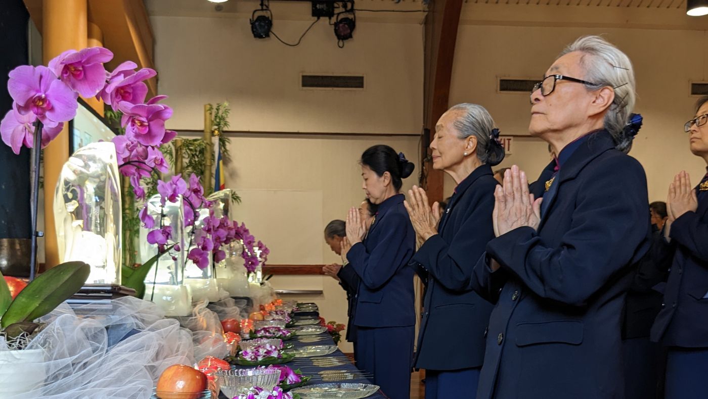 Carefully arranged flowers line the ceremonial space as participants offer sincere prayers. Photo/Julie Sun